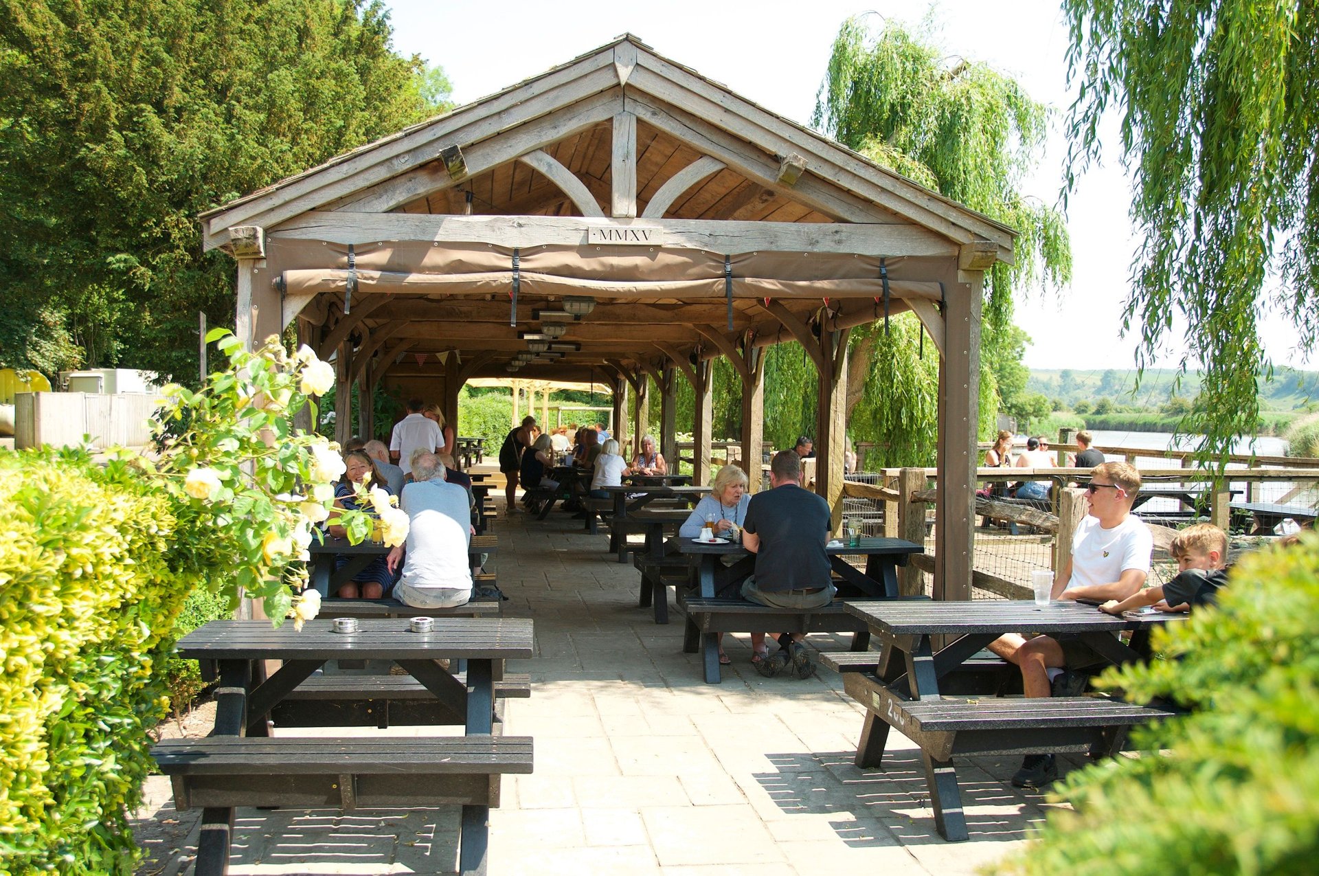 The timber-framed covered terrace at The Black Rabbit, with willows and the river beyond