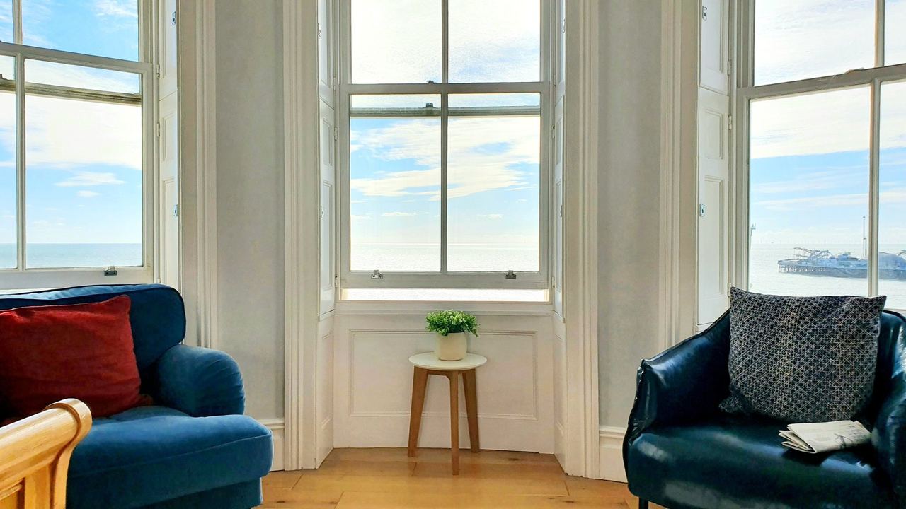 Blue armchairs in the bay window of a sea-view room at A Room With A View