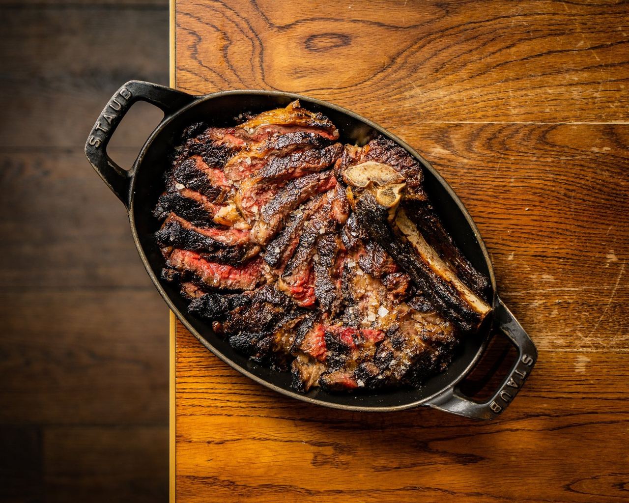 A charred steak on the bone in a cast-iron dish at The Coal Shed