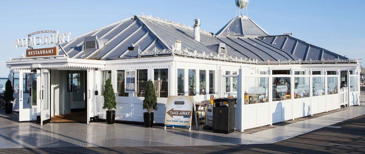 The white Palm Court restaurant building on Brighton Palace Pier in sunshine