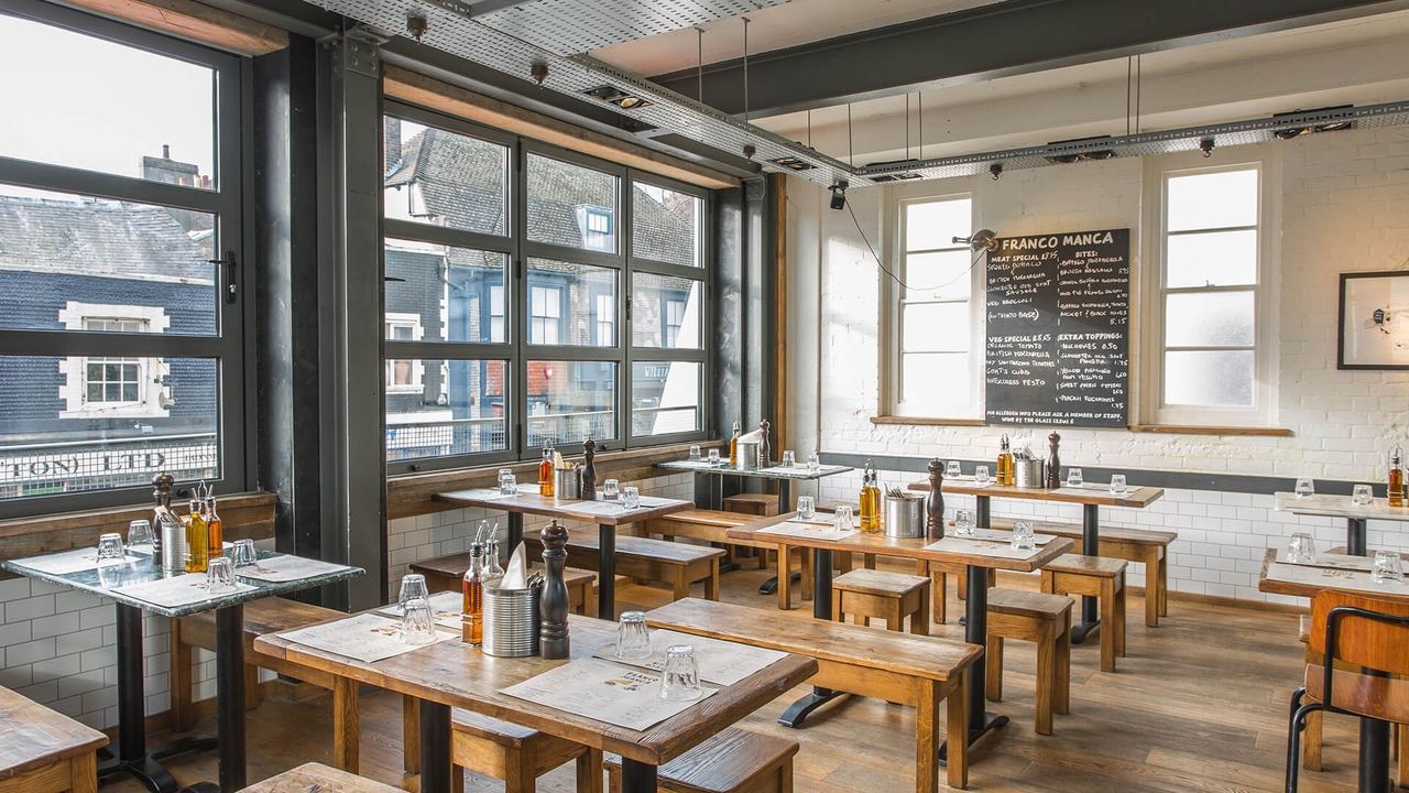 The light dining room of Franco Manca, with wooden tables and big windows