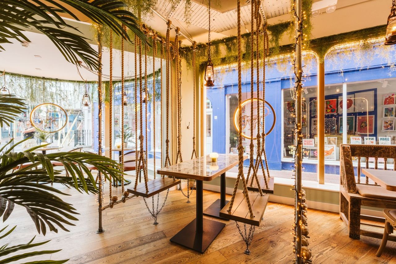 Swing seats and hanging greenery inside Mowgli Brighton