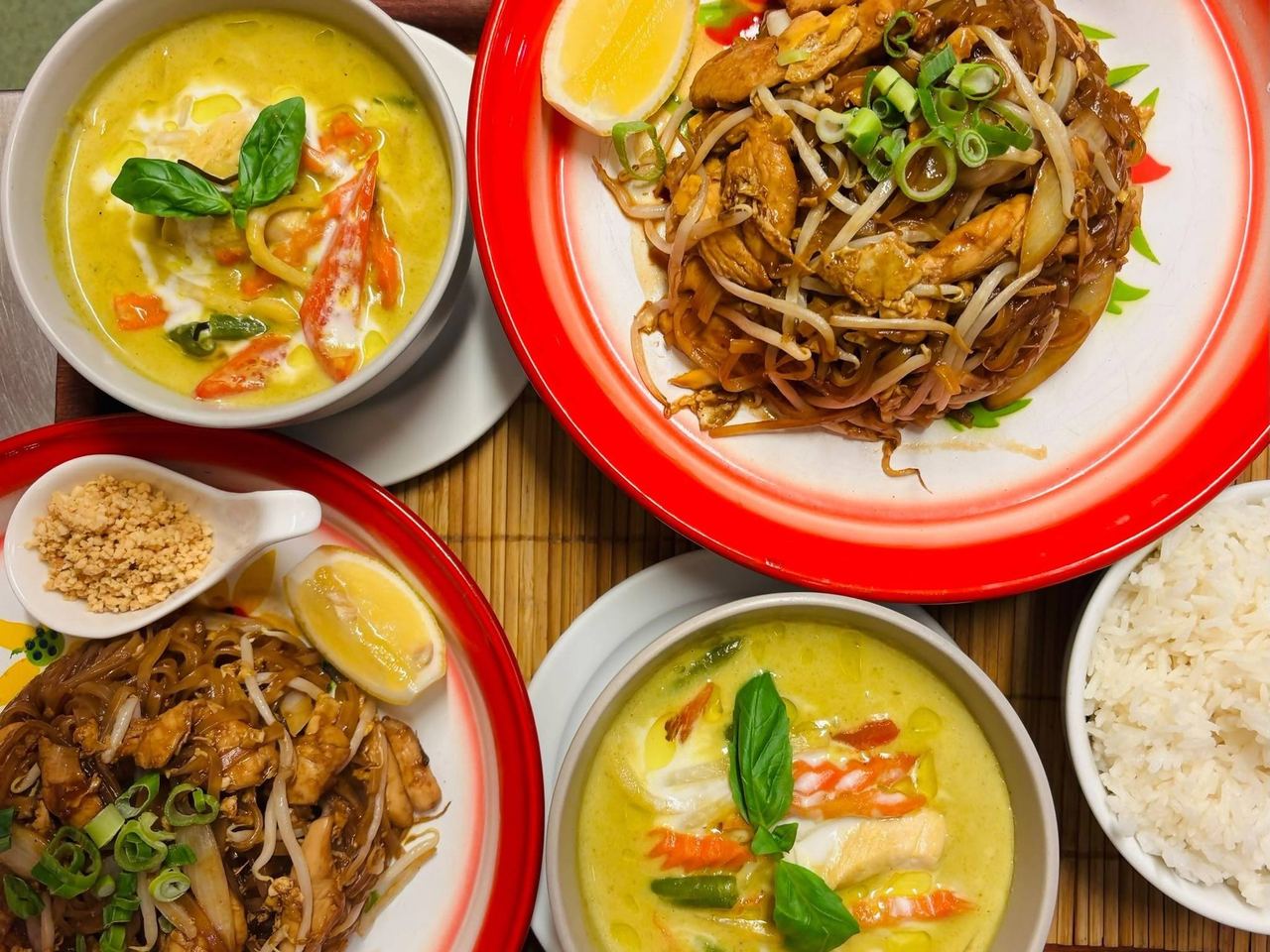 Green curry, pad thai and rice on the table at Sabai Thai