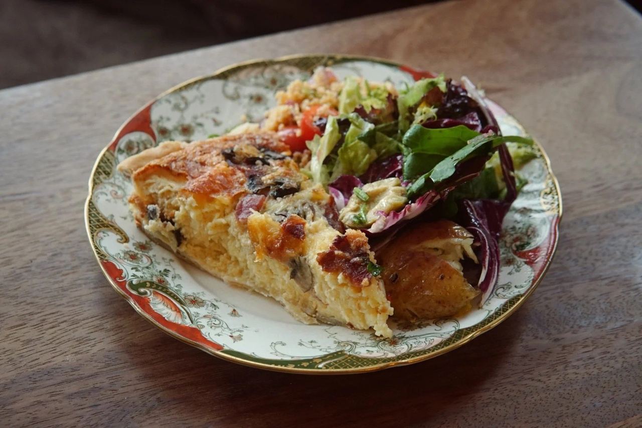 A slice of quiche with salad on a vintage plate at Marmalade
