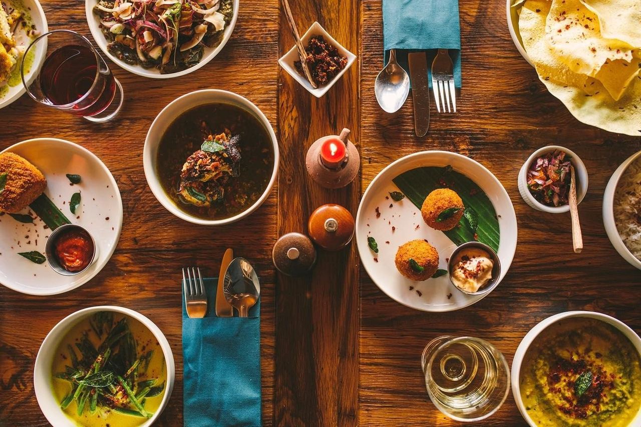 Sri Lankan short eats, curries and poppadoms laid across a table at Colombo House
