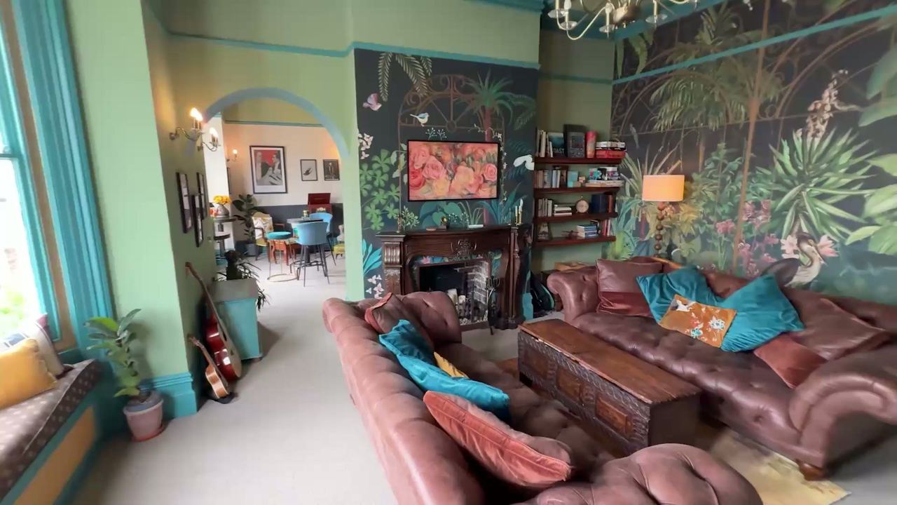 The lounge at The Sheldon, with a jungle mural, leather sofas and a fireplace