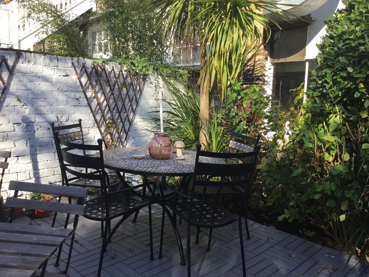 The courtyard garden at Café 32, with palms and a mosaic table
